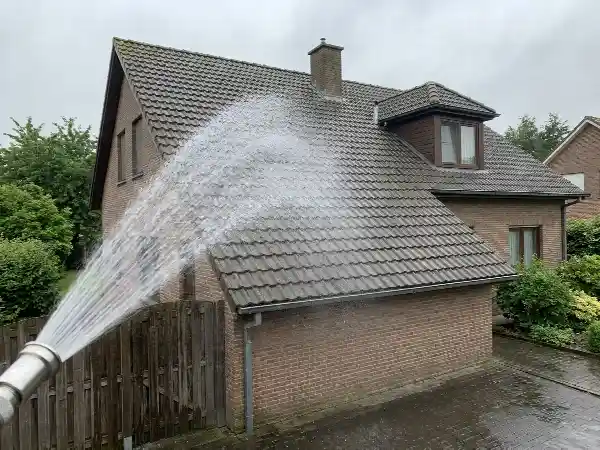 Rinçage doux d'une toiture en tuiles béton, jet large de haut en bas